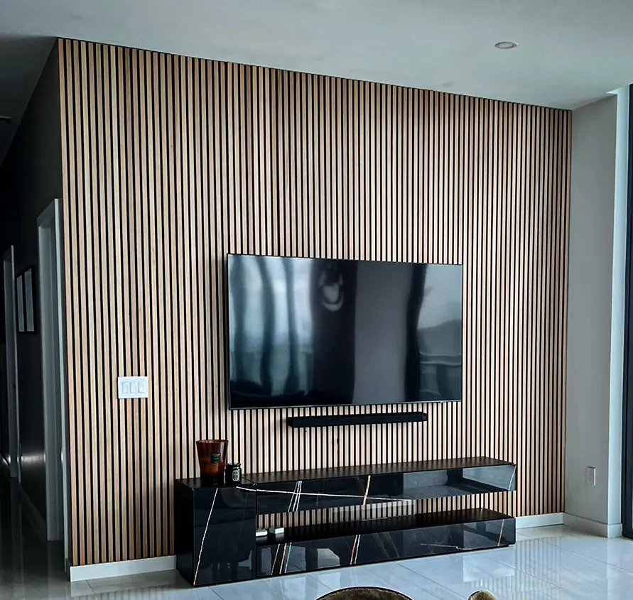 Custom entertainment TV wall with fluted wood slat panel and black marble console in Coral Springs, FL