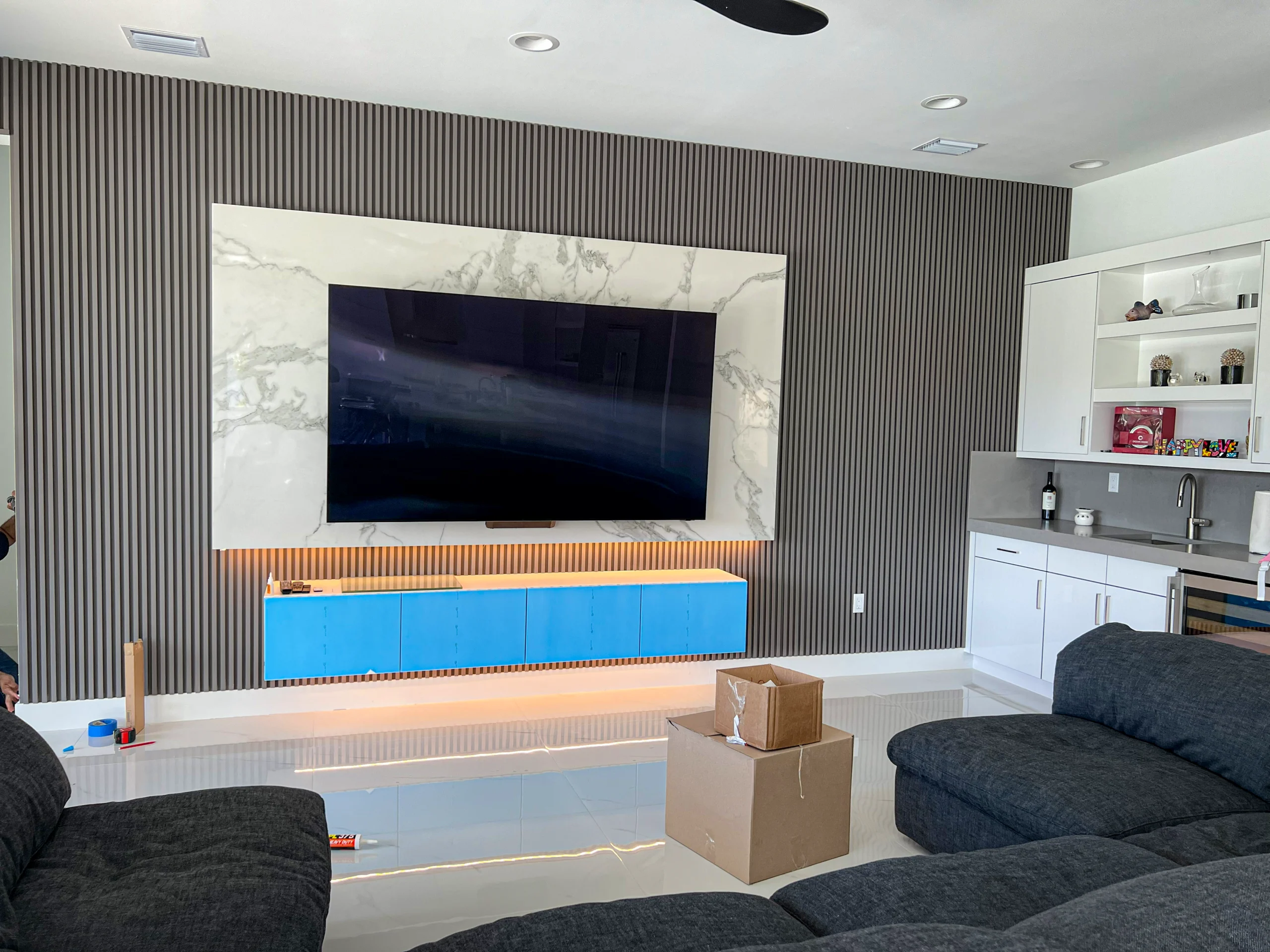 Custom entertainment wall with built-in linear fireplace, fluted panel, marble accent, and LED in Parkland, FL