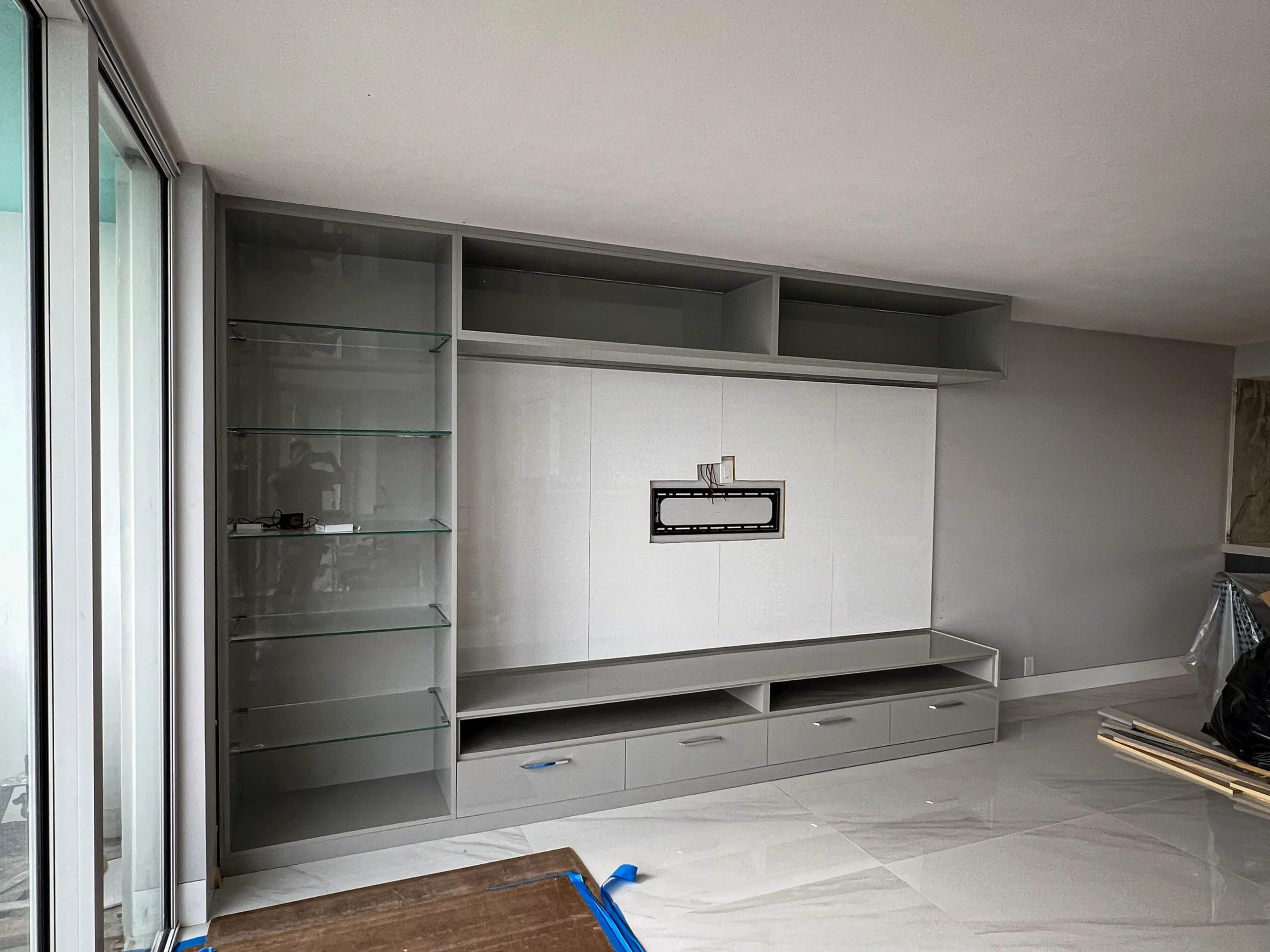 Custom floor-to-ceiling entertainment center with wood panel and oceanview console in Boca Raton, FL