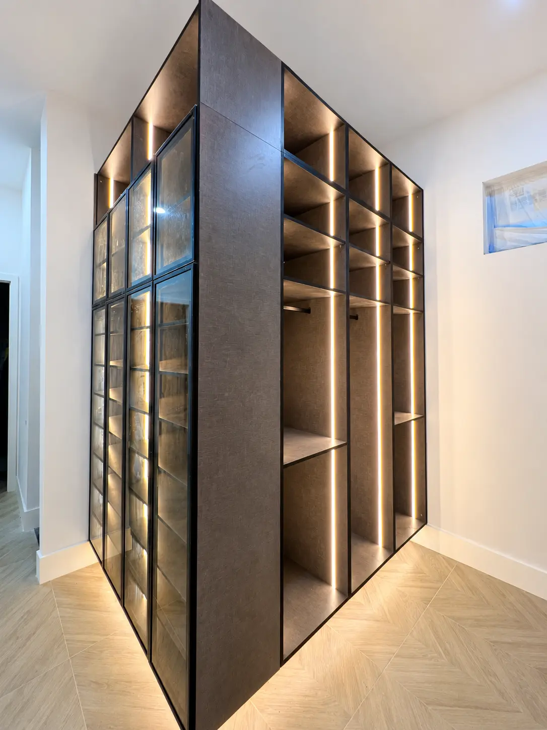 Modern custom walk-in closet with glass doors and integrated lighting by Custom Closet Florida